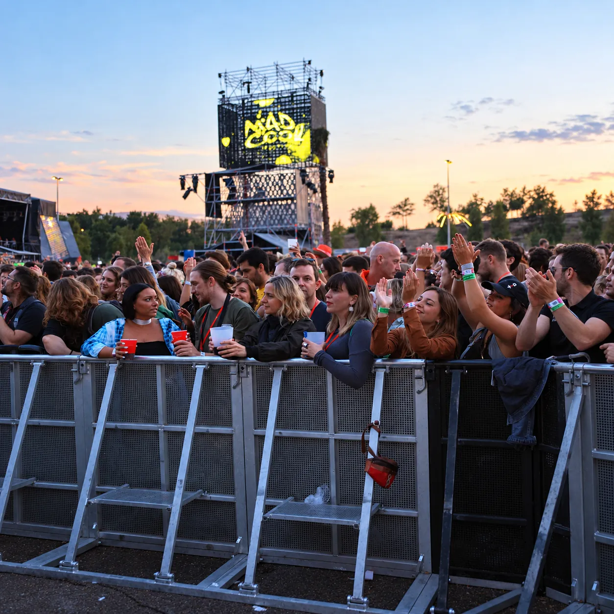 Festival crowd at an aluminium Mojo Barrier line at dusk