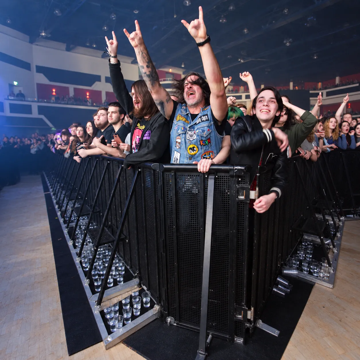 Fans at a black Mojo Barrier line during an indoor concert