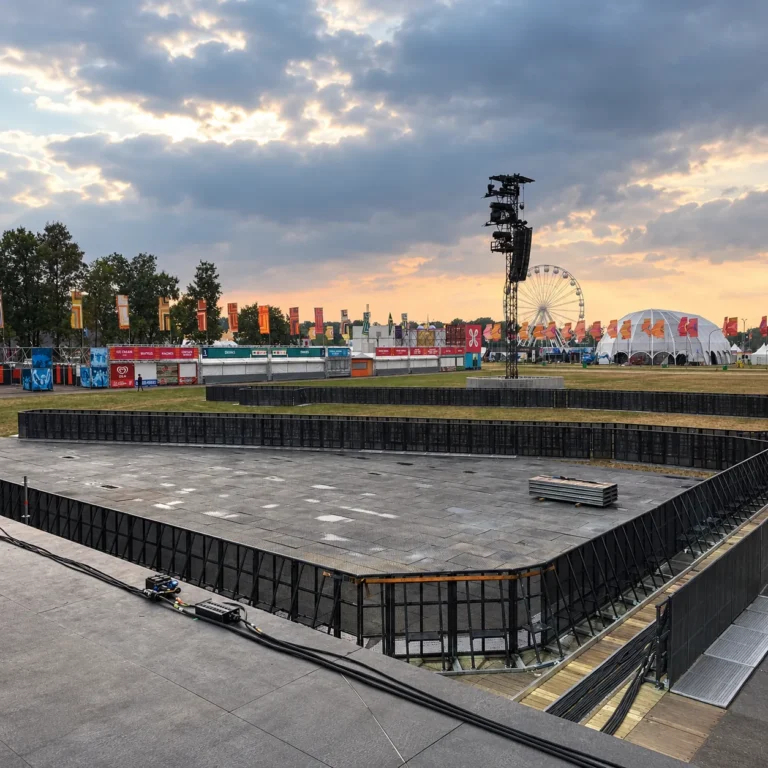 Black Mojo front-of-stage barrier lines at a festival at sunset