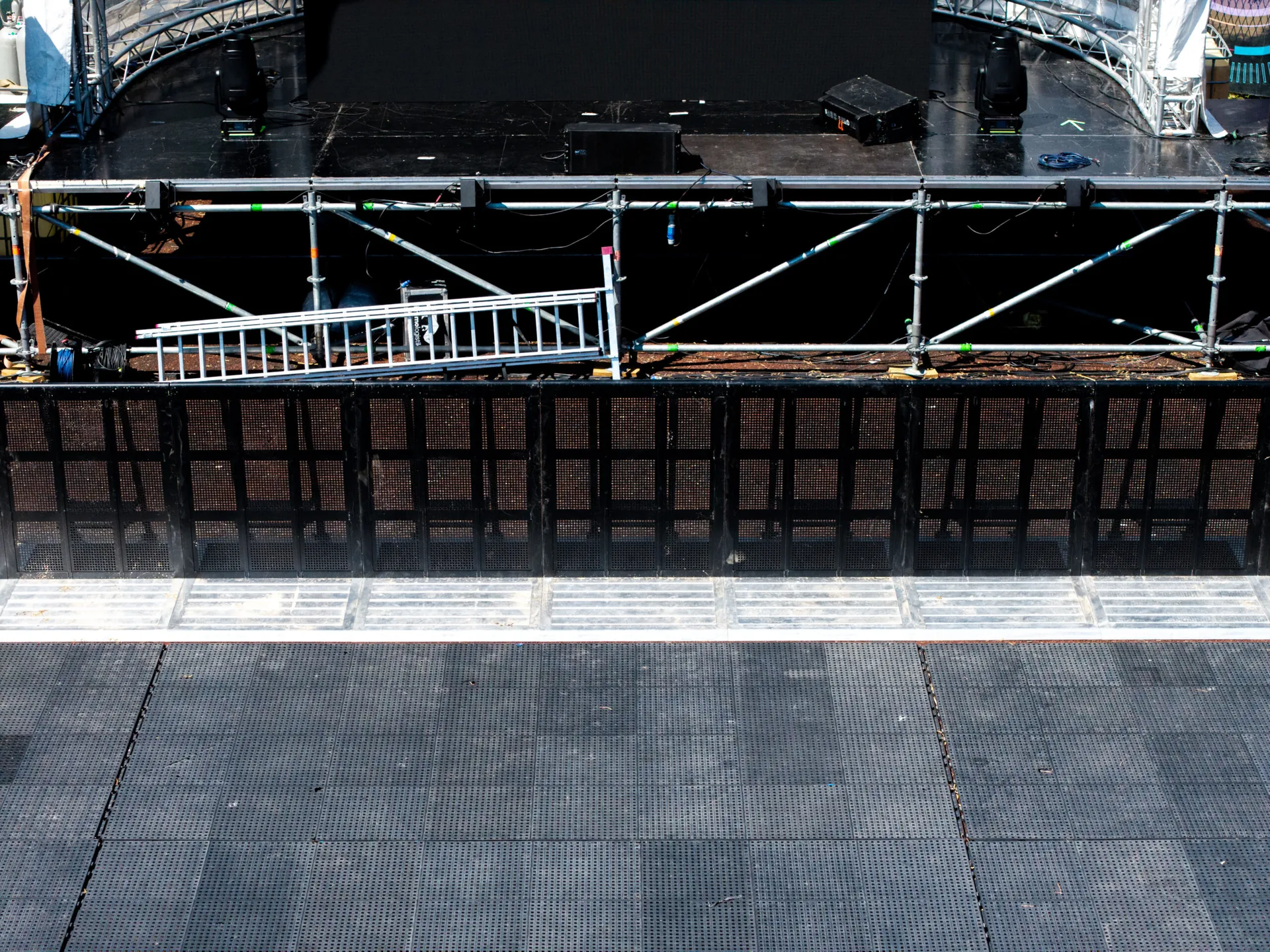 Black Mojo Barrier line with silver floor plates in front of a stage, from above