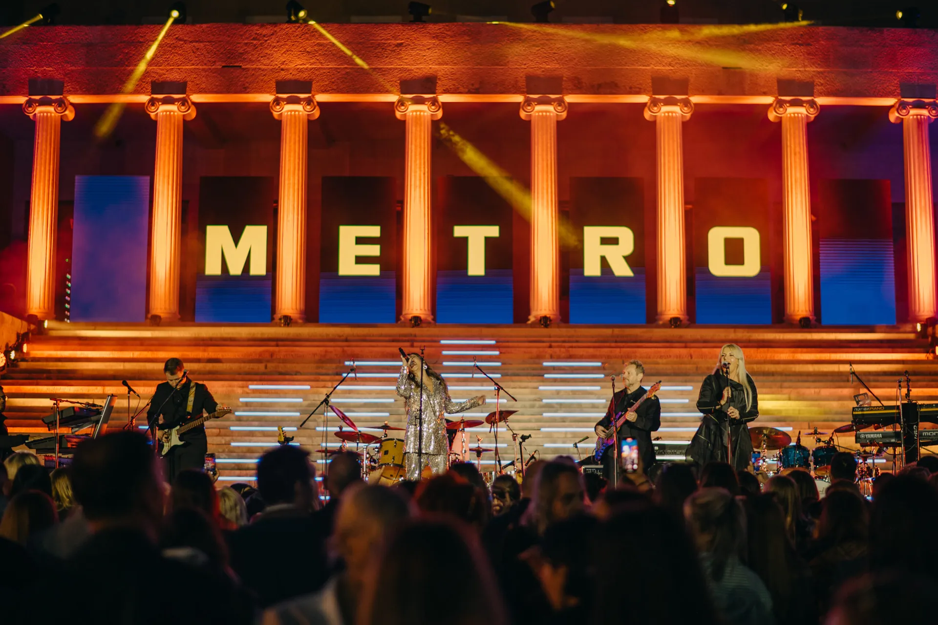 Guests in front of a live band on stage at a corporate event