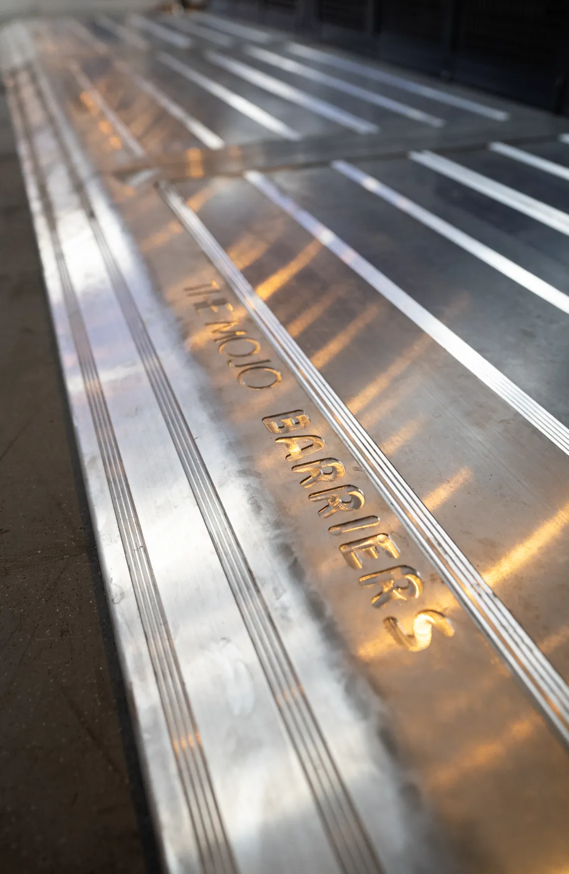 Embossed MOJO BARRIERS logo on aluminium, detail
