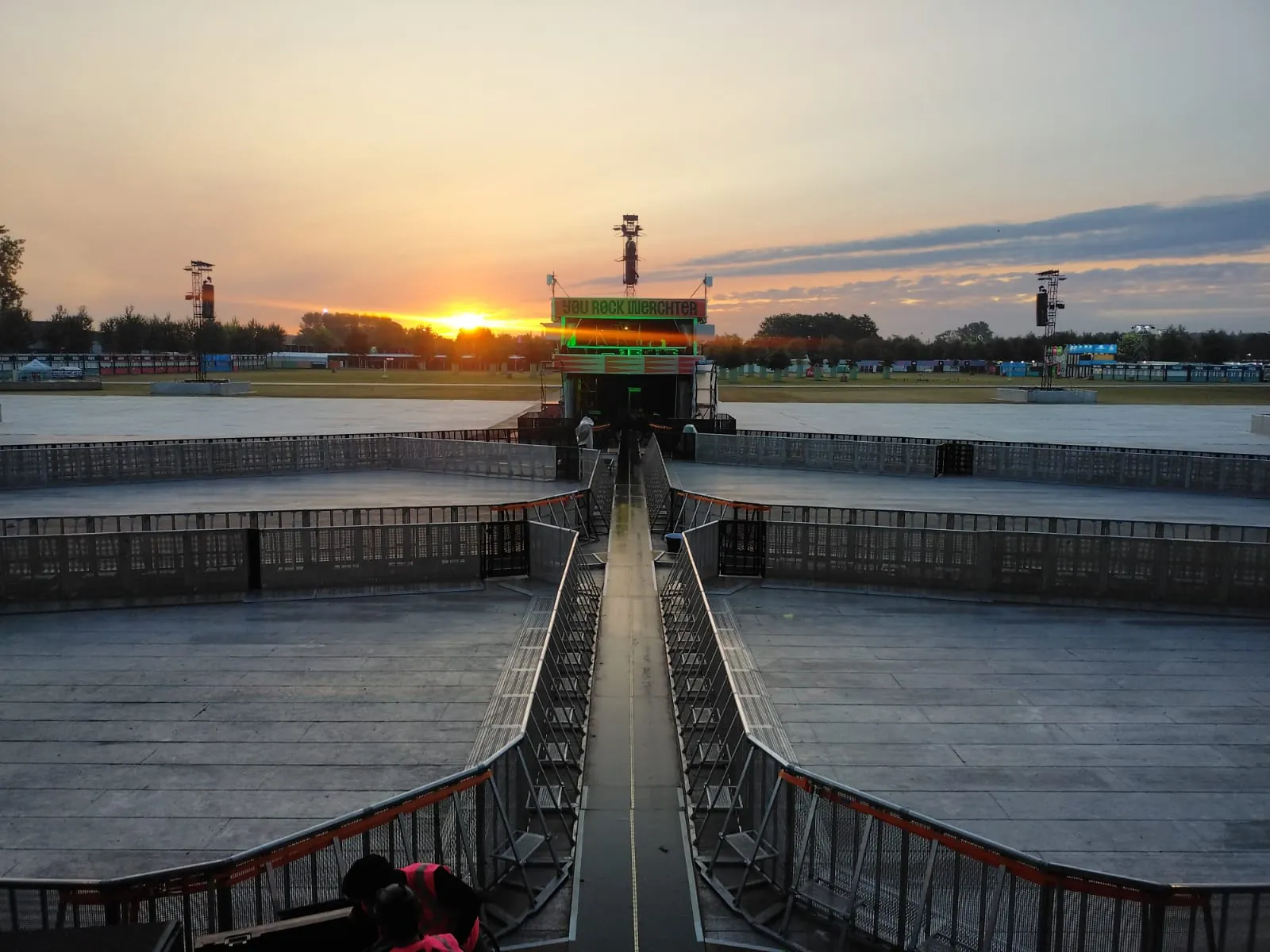 Aluminium Mojo Barrier lines and a central walkway in front of the main stage at Rock Werchter at sunset